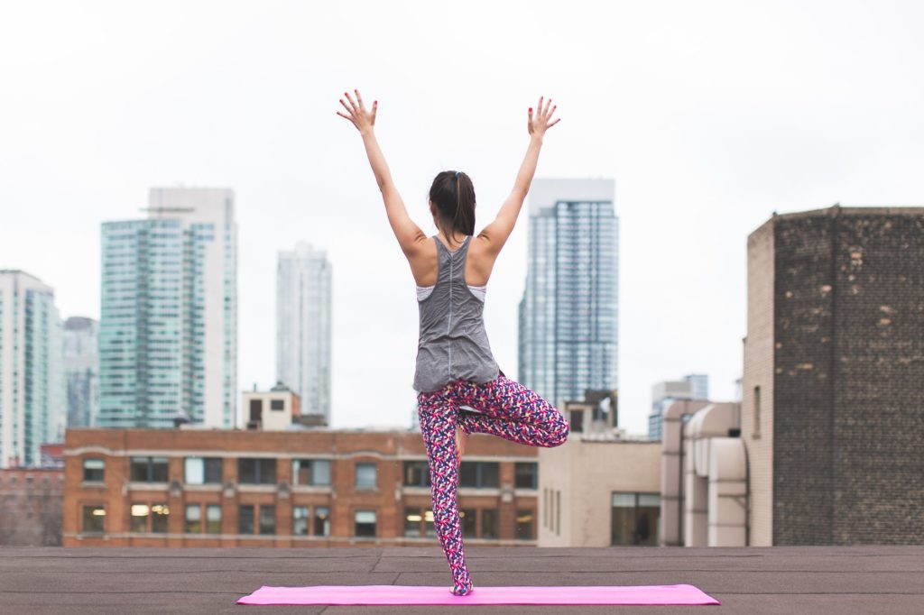 yoga à la pause en entreprise. On voit une femme qui fait une pose dans une ville.